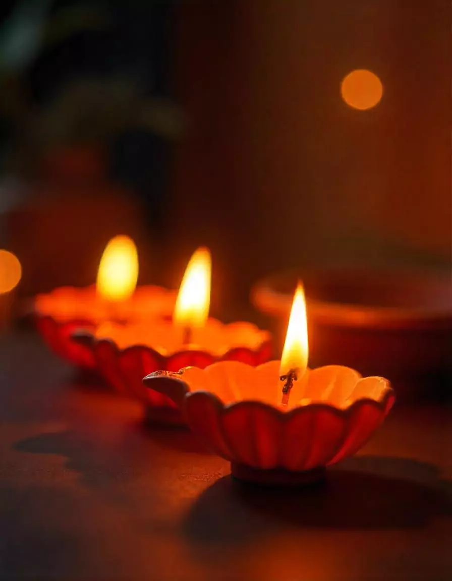 Three beautifully lit clay diyas with warm orange flames, creating a serene Diwali ambiance | Elegant Diya Arrangement for Diwali 2023 | Diwali Decorations | Decorations Guru