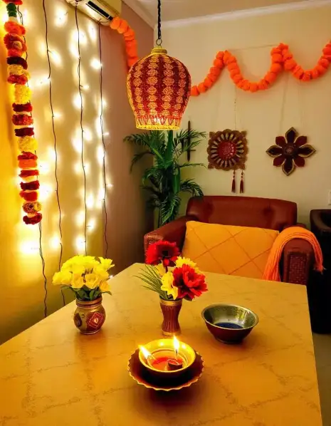 Brightly lit living room decorated with marigold garlands, Diwali lantern, and diyas. | Festive Living Room Diwali Decoration | Diwali Home Decorations | Decorations Guru