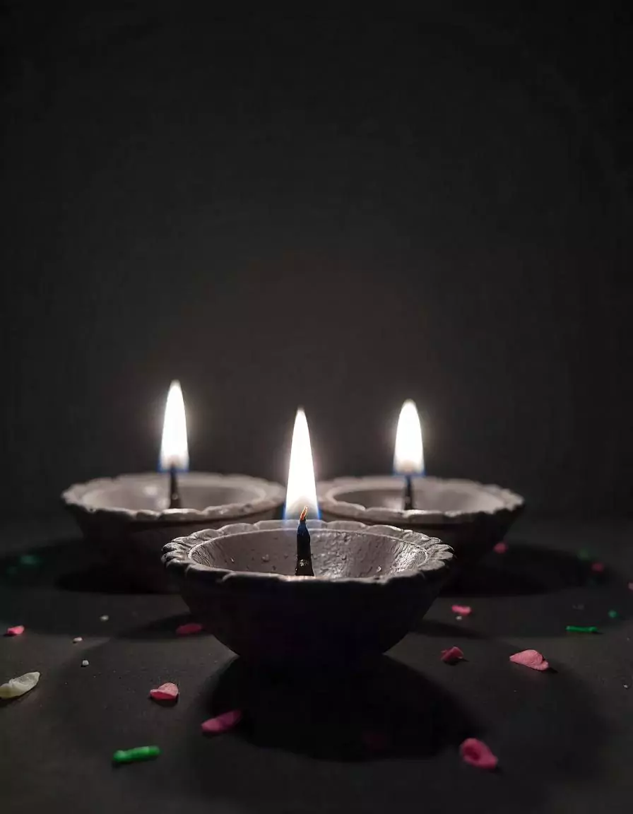 Traditional Diwali diyas with lit flames and flower petals, creating a warm festive ambiance | Traditional Diwali Diyas Decoration | Festival Décor Ideas - Diwali | Decorations Guru